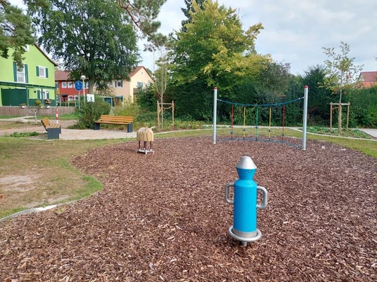 Ein moderner Spielplatz mit zahlreichen Klettermöglichkeiten, umgeben von grüner Natur.
