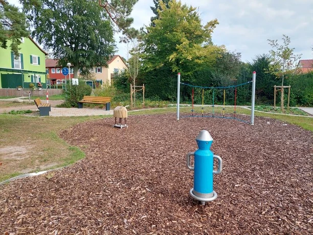 Ein moderner Spielplatz mit zahlreichen Klettermöglichkeiten, umgeben von grüner Natur.