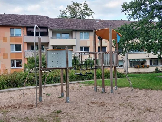 Es ist eine Kletterburg im Sandkasten zu sehen.