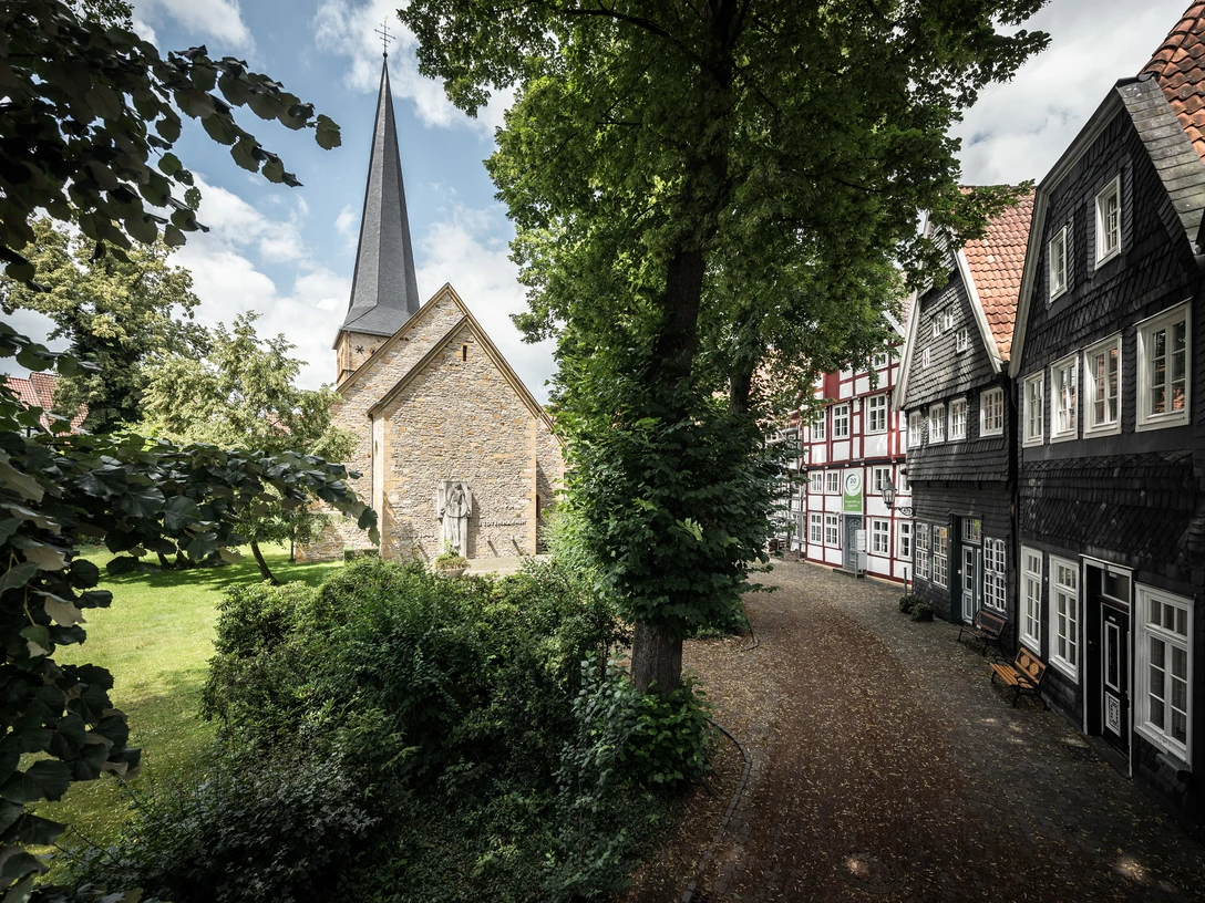 Kirchplatz Apostelkirche © Detlef Güthenke.jpg Kirchplatz mit Apostelkirche, spitzem Turm, Fachwerkhäusern und Bäumen in Gütersloh