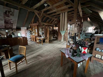 Ein historischer Innenraum aus Holz mit verschiedensten alten Handwerksgeräten und Exponaten.
