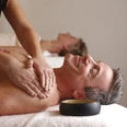 H2O Refugium - Freizeiteinrichtungen Stadtwerke Herford GmbH (2).JPG Ein Mann mittleren Alters genießt eine entspannende Rückenmassage in einem Wellness-Bereich.