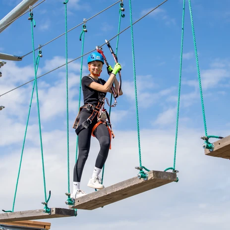 La photo montre une femme grimpant sur un élément d'escalade dans le parc d'escalade de Markkleeberg.