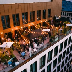 Ruby Louise Hotel & Bar - Dachterrasse Abendszene auf belebter Rooftop-Bar mit Lichterketten