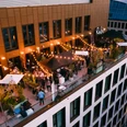 Ruby Louise Rooftop Area.jpg Abendszene auf belebter Rooftop-Bar mit Lichterketten