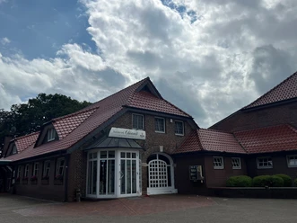 Bild1.jpg Ein hübsches Backsteinhaus mit rotem Dach und dem Logo "Chianti" unter bewölktem Himmel.