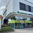 Koopmann Apotheke.jpg Die Koopmann Apotheke ist ein modernes Gebäude mit großer Glasfassade und hellen Schildern.