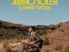 Alvaro Soler läuft durch eine felsige Wüstenlandschaft mit einem Koffer voller Aufkleber, Tourdaten 2026.