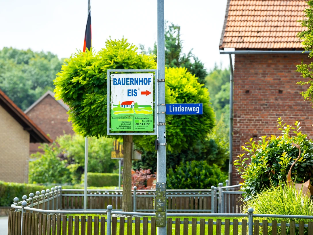 Foto-208.jpg Ein Wegweiser mit der Aufschrift "Bauernhof Eis" führt zum Lindenweg in einem ländlichen Dorf.