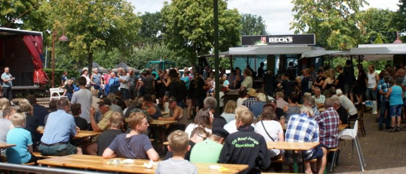 Zwischenberger Fest 3.jpg Eine lebhafte Menschenmenge genießt das Zwischenberger Fest, umgeben von Gastronomieständen und schattenspendenden Bäumen.