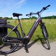 Radfahren in der Mittelweser-Region Ein modernes E-Bike steht auf einem Feldweg vor einer blühenden Wiese mit Mohnblumen und blauem Himmel.