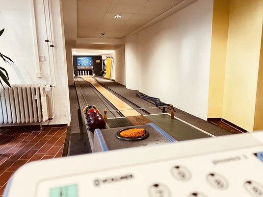 Kegelbahn (4).JPG Eine traditionelle Kegelbahn mit mehreren bunten Kugeln und einem langen, rechteckigen Wurfbahn.