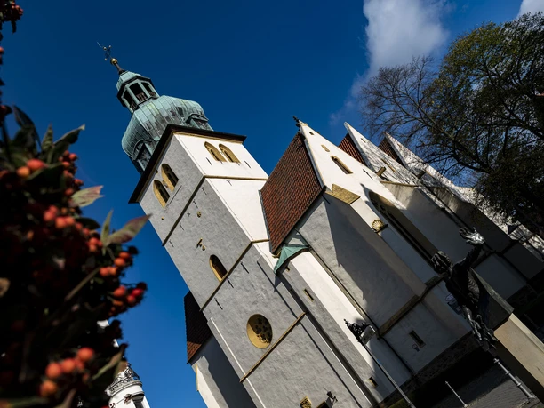 Herford_Pilgerkirche St Jakobi_Pro Herford GmbH-Karabasch.jpg Pilgerkirche St. Jakobi mit charakteristischem Turm unter blauem Himmel, umgeben von Bäumen.