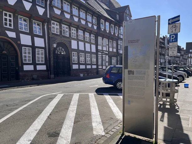 PS.Pfad, Schild D Infostele des PS.Pfads zum Einbecker Bier an einer Straße mit Fachwerkhäusern in Einbeck.