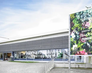 Ahlers Fashion Outlet Herford-WTW Adolf Ahlers Stiftung & Co KG Herford Moderne Gebäudefassade des Ahlers Fashion Outlet Herford mit großen Glasfronten und Plakat.