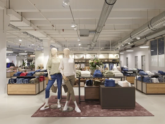 BRAX Outlet Herford-Leineweber GmbH & Co KG(3).jpg Das BRAX Outlet in Herford zeigt eine moderne Verkaufsfläche mit stilvoll gekleideten Schaufensterpuppen.