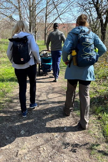 Wanderer spazieren auf einem naturnahen Weg durch eine bewaldete Landschaft in der Mittelweser-Region.