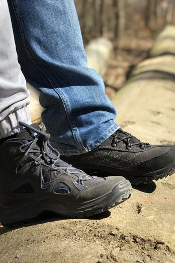 Zwei Paar Wanderstiefel auf einem umgestürzten Baumstamm im bewaldeten Gebiet der Mittelweser-Region.