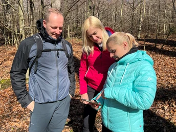 Wandern in der Mittelweser-Region Drei Menschen studieren eine Karte beim Wandern in einem lichtdurchfluteten, laubigen Waldgebiet.Three people study a map while hiking in a light-flooded, leafy woodland.Tre personer studerer et kort, mens de vandrer i en lys, løvfyldt skov.Drie mensen bestuderen een kaart tijdens een wandeling in een met licht overgoten, lommerrijk bos.