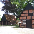 Heimathof Emsbüren – Backhaus ©Emsland Tourismus GmbH (1).jpg Backhaus mit rotem Fachwerk und dunklen Balken auf dem Heimathof Emsbüren, umgeben von Bäumen.