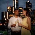 Sofitel Frankfurt Opera - Gäste Paar mit Sektgläsern auf Rooftop mit Skyline bei Nacht