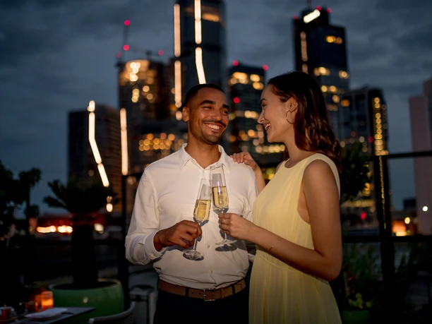 Sofitel Frankfurt Opera - Guests Couple with champagne on rooftop, city skyline at night