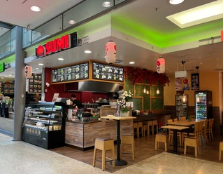 Sumi.jpg Ansicht des Restaurants bzw. des Bedientresens von vorne. Rechts daneben sieht man einen Sitzbereich mit Tischen und Stühlen.