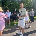 Weinwandern Timo Strauss mit einer Weinflasche in der Hand steht vor einer Gruppe Menschen mit Weingläsern in der Hand