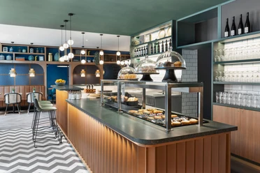 Comptoir avec étalage de pâtisseries au Koko Café & Bar du Stay Kooook Hotel Leipzig dans la Gottschedstraße