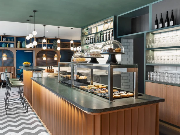Comptoir avec étalage de pâtisseries au Koko Café & Bar du Stay Kooook Hotel Leipzig dans la Gottschedstraße