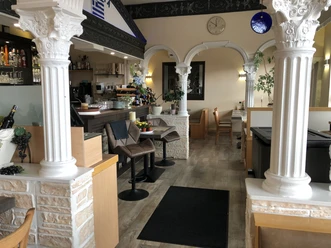 Restaurant Olympia Restaurant mit klassisch-griechischen Säulen und einladender Atmosphäre innen; Bar und Sitzbereiche.