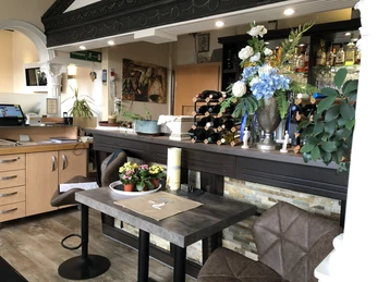 Restaurant Olympia Einladendes Restaurant mit dekorierten Tischen, eleganter Theke und schönem Blumenschmuck im Vordergrund.Inviting restaurant with decorated tables, elegant bar and beautiful floral decorations in the foreground.Indbydende restaurant med pyntede borde, elegant bar og smukke blomsterdekorationer i forgrunden.Uitnodigend restaurant met gedekte tafels, elegante bar en prachtige bloemdecoraties op de voorgrond.