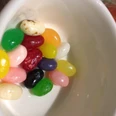 test-poi Eine weiße Schale voller bunter Jelly Beans in verschiedenen Farben wie Rosa, Gelb und Grün.
