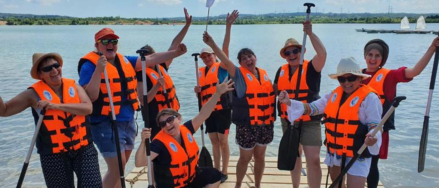 Raft building with raft trip or race, also for large groups A group of people on a raft in the water.