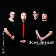 Vier Bandmitglieder in schwarzer Kleidung, einer mit roter Krawatte, vor schwarzem Hintergrund.