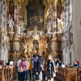 Radpilgern - Wieskirche Innenansicht einer barocken Kirche mit kunstvoll verzierten Wänden und Besuchern.