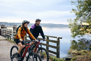 Radpilgern - Kloster Bernried Zwei Radfahrer auf einem Weg am See in herbstlicher Landschaft.