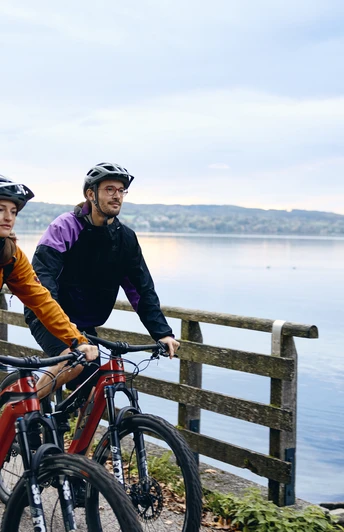 Radpilgern - Kloster Bernried Zwei Radfahrer auf einem Weg am See in herbstlicher Landschaft.