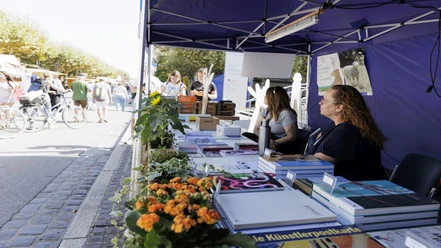 Verkaufsstand für Bücher Buchstand unter Zelt auf Straßenfest mit Besuchern