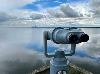 Beobachtungsturm Winzlarer Turm Teleskop am Winzlarer Turm mit weitem Blick auf den wolkigen, spiegelnden See an einem klaren Tag.