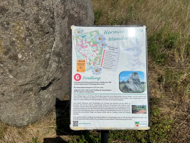 Een kei in het gras met een informatieve plaquette met details over de geschiedenis en de locatie.