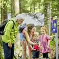 Familie unterwegs auf dem Goldi Gwundernasenweg in Seelisberg
