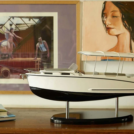 Canito l'acqua - Exklusive Bootfahrt in Leipzig Das Modell eines Bootes steht auf einem Sideboard, im Hintergrund hängen zwei Kunstwerke