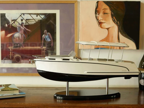 Canito l'acqua - Exklusive Bootfahrt in Leipzig Das Modell eines Bootes steht auf einem Sideboard, im Hintergrund hängen zwei Kunstwerke