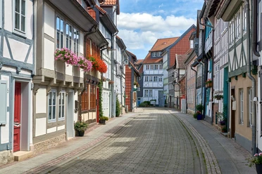 WF-Krumme-Strasse-Blumen.jpg Fachwerkgasse, an den Häusern hängen Blumentöpfe mit Geranien