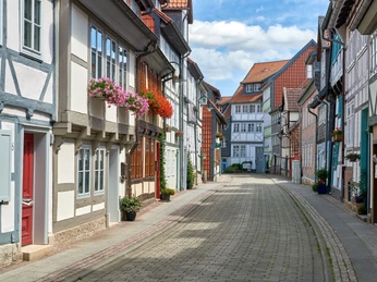 WF-Krumme-Strasse-Blumen.jpg Fachwerkgasse, an den Häusern hängen Blumentöpfe mit Geranien
