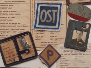 Werksausweise und Aufnäher von ehemaligen Zwangsarbeitern aus der Ausstellung der Gedenkstätte
