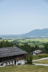 Himmlisch genießen - Glenleiten Altes Bauernhaus mit Schieferdach in grüner Landschaft und Blick auf Berge.