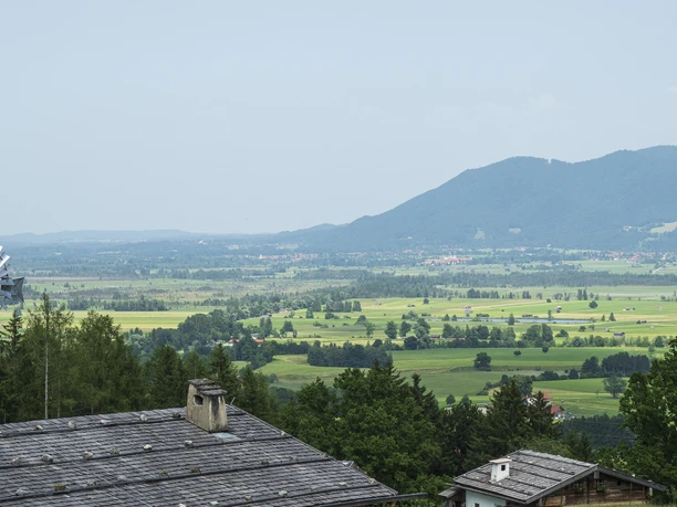 Himmlisch genießen - Glenleiten Altes Bauernhaus mit Schieferdach in grüner Landschaft und Blick auf Berge.