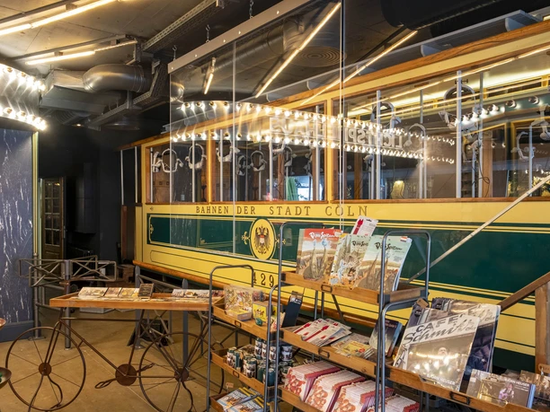 TimeRide A historic streetcar of the city of Cologne. There are shelves with brochures at the front.